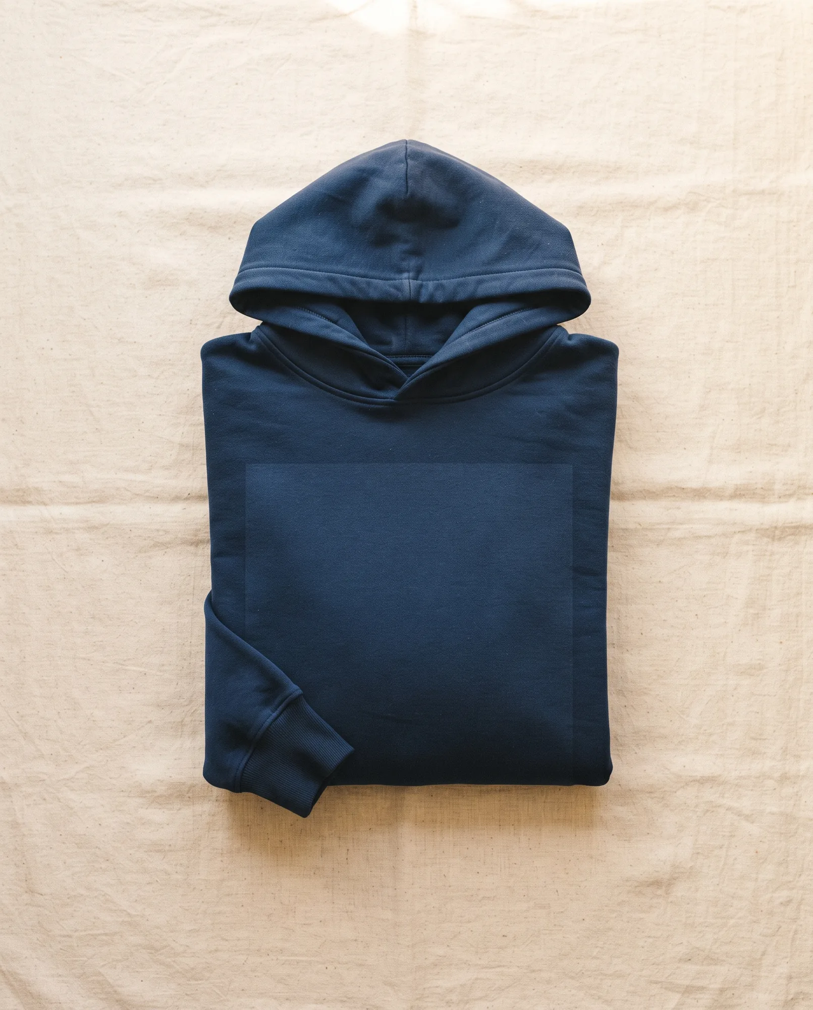 Zusammengelegter dunkelblauer Hoodie auf Leinen